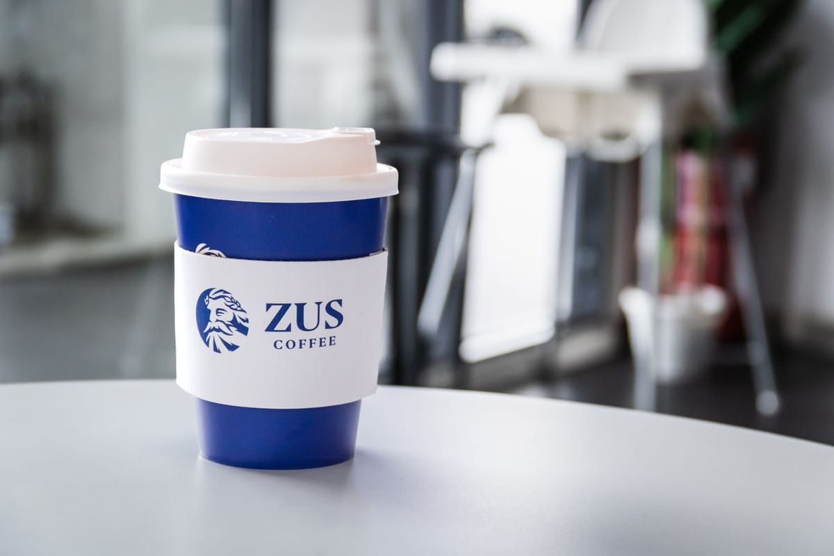 Branded takeaway coffee cups on a counter