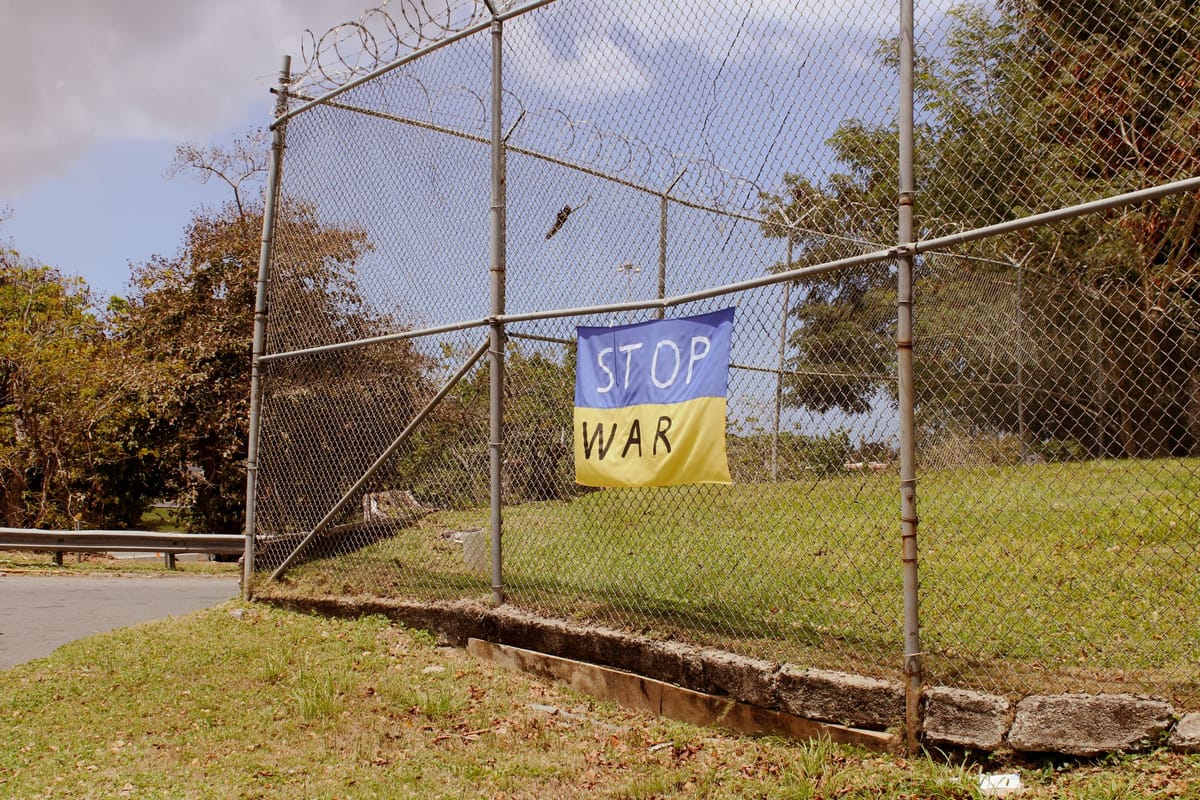 A banner fixed to a fence with cable ties through eyelets
